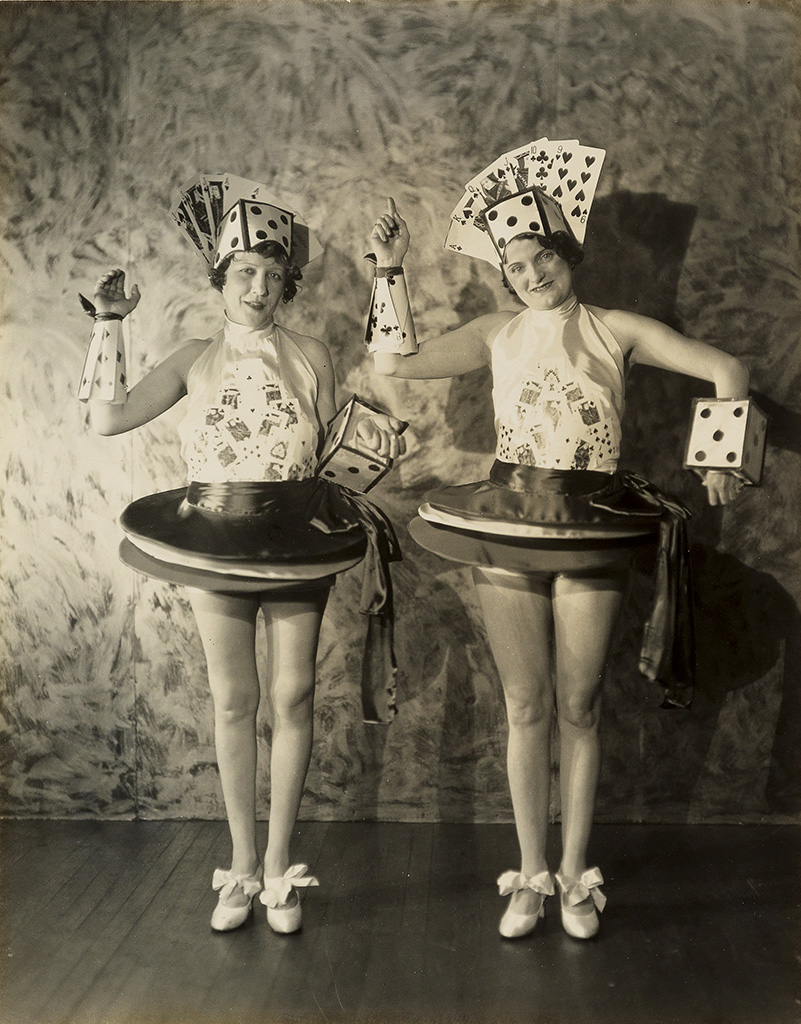 (FLAPPER VERNACULAR) Pair of flapper-era women dressed in poker outfits, with headwear featuring a full house and a straight.